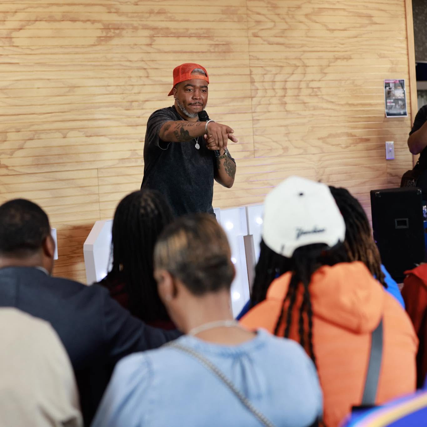 Jay.R Fogle speaking to a seated audience in a bright room
